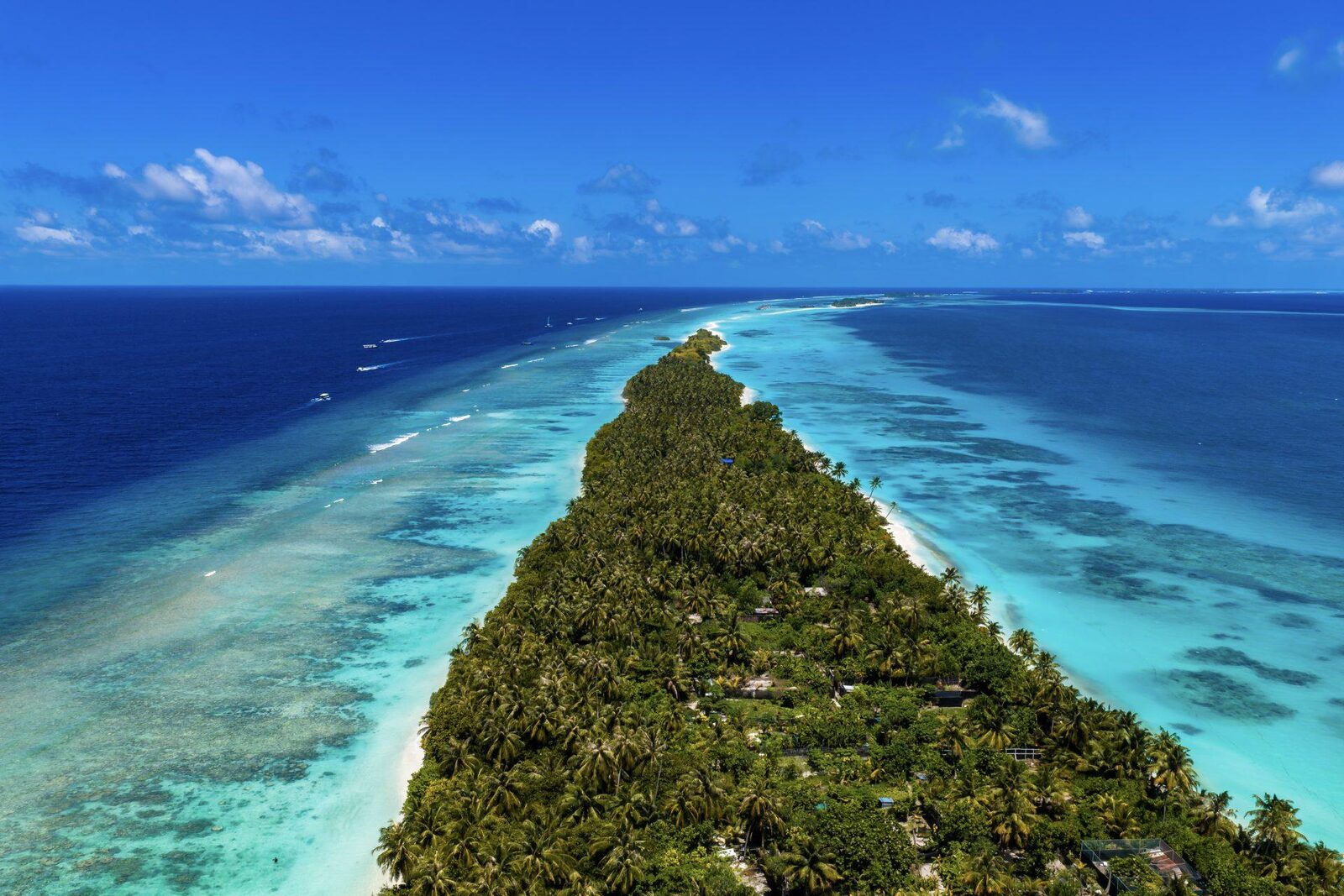 Aerial view of Dhigurah's narrow tip reaching out into the reef